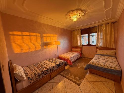 Un dormitorio con dos camas y una lámpara. en Anza Lighthouse, en Agadir