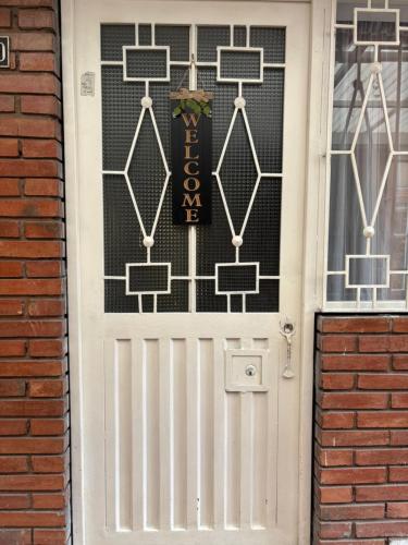 Apartamento cerca al aeropuerto في بوغوتا: باب أبيض عليه لافتة