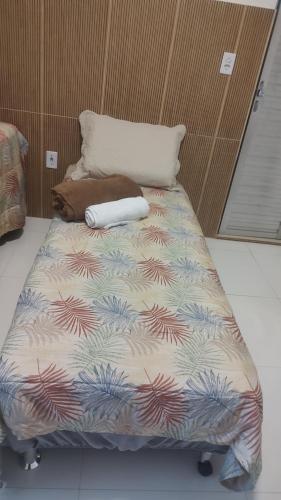 a bed with a colorful comforter in a room at Suíte Aconchego na Casa 68 in Belém