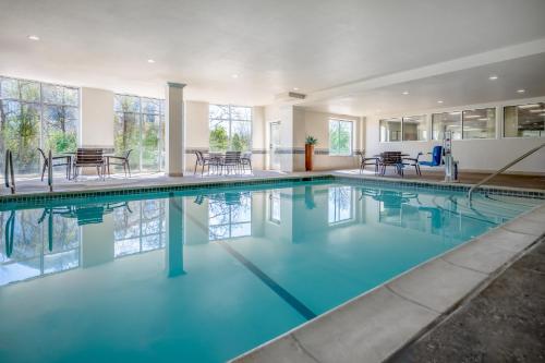 a swimming pool with blue water in a building at Hyatt Place College Station in College Station