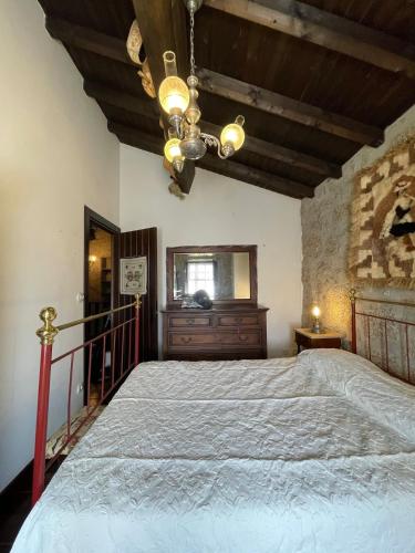 a bedroom with a large bed and a chandelier at Herdade de Açores in Aldeia Rica