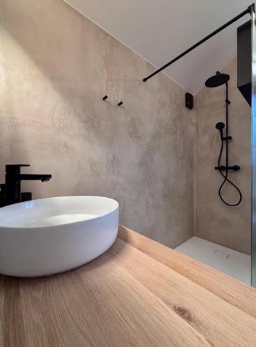 a bathroom with a white tub and a shower at Idyllic cottage with wellness facilities in Alveringem