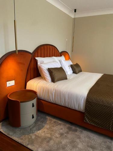 a bedroom with a large bed with a wooden headboard at Casa Correio Boutique Hotel in Valença