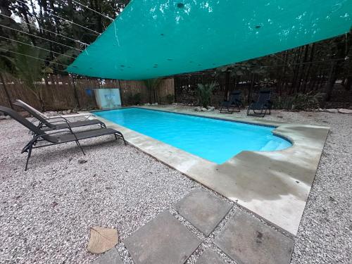 a swimming pool with a chair and a umbrella at Loft en San José de pinilla avellanas guanacaste in San José Pinilla