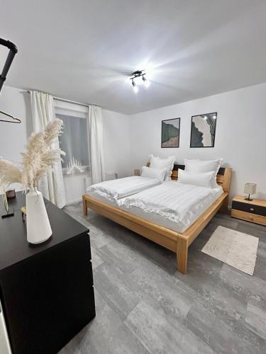 a bedroom with a bed with white sheets and pillows at Ferienwohnung Paradies in Osnabrück