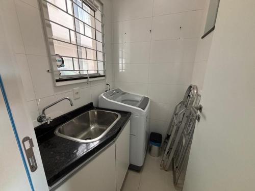 Una pequeña cocina con fregadero y ventana. en Dúplex con impresionantes vistas al mar RAT002, en Perequê