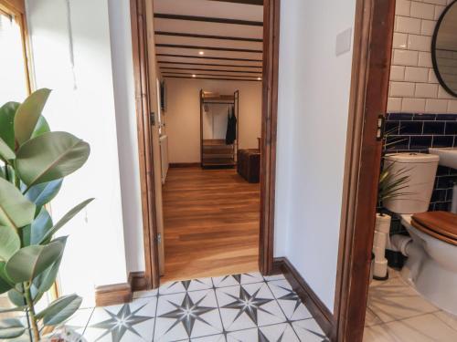 een hal die leidt naar een badkamer met een spiegel bij Quarry Barn in Gresford