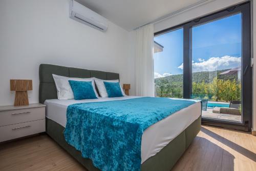 a bedroom with a bed and a large window at Holiday House Omis - Naklice in Omiš