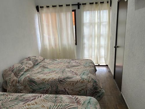 a living room with a couch next to a window at Casa Regina in Tepoztlán