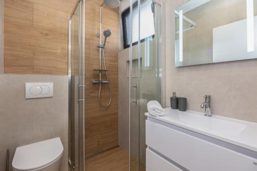 a bathroom with a shower and a toilet and a sink at Holiday House Omis - Naklice in Omiš