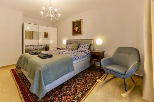 a bedroom with a bed and a chair at Next to the Ski Lift Downtown Bansko in Bansko