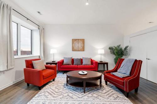 a living room with two red chairs and a table at Spacious 3BR Urban Getaway w Gym in Chicago