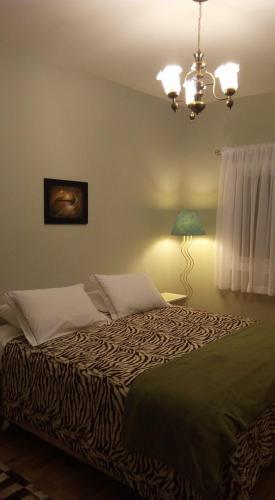 um quarto com uma cama grande e um candeeiro em Hospedagem domiciliar Gramado em Gramado