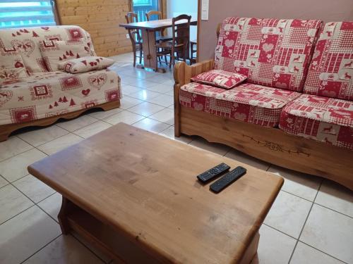 a living room with two remote controls on a coffee table at gite des granges bailly in Les Fourgs