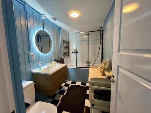a bathroom with a sink toilet and a mirror at Casa Divera in Noordwijkerhout