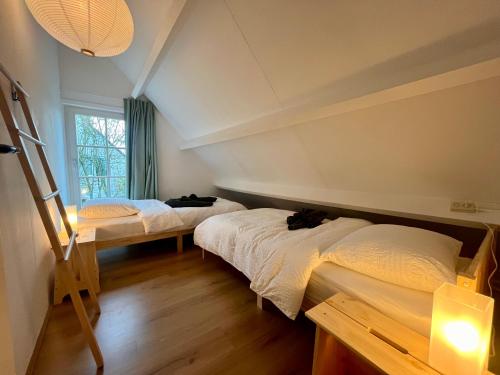 a bedroom with two beds and a window at Casa Divera in Noordwijkerhout