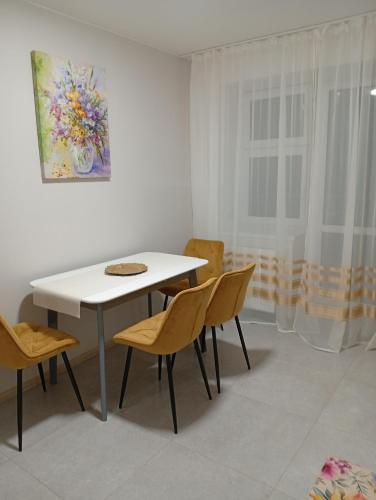 una sala da pranzo con tavolo e sedie bianchi di Serenity a Ternopilʼ