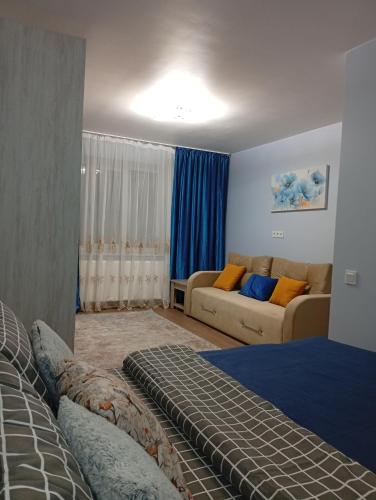 un soggiorno con un letto e un divano di Serenity a Ternopilʼ