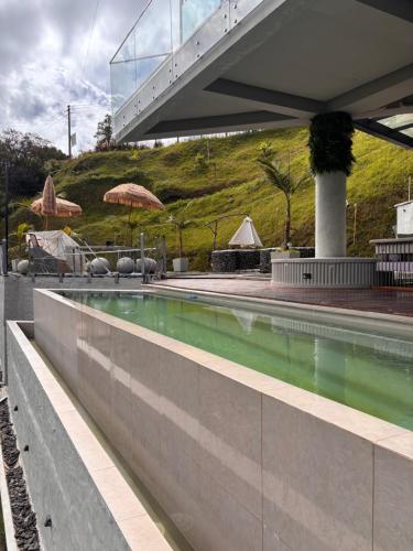 uma piscina com água verde num edifício em Habitación en Guatape Deluxe Standard Suite em Guatapé