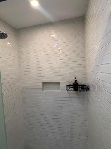 a white tiled bathroom with a man sitting on a shelf at NIDO Hotel in San Miguel de Allende