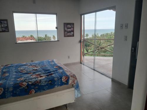 a bedroom with a bed and a view of the ocean at Casa de praia Laranja a beira-mar in Ilhéus