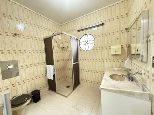 Un baño con ducha, inodoro y lavabo. en Pousada Dona Lidia Express, en Campo Mourão