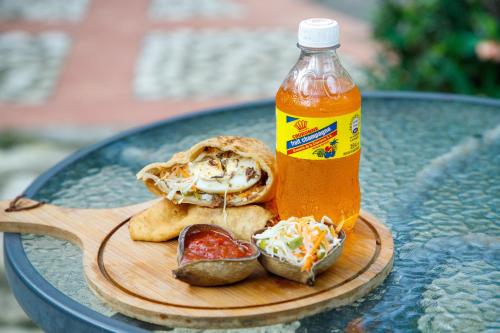 un tavolo con un piatto di cibo e una bottiglia di salsa di Lakou Breda a Cap-Haïtien