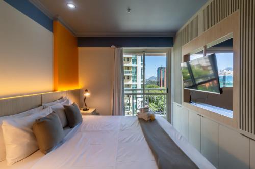een slaapkamer met een groot bed en een flatscreen-tv bij Pineapples BPremium - Excelentes suítes in Rio de Janeiro