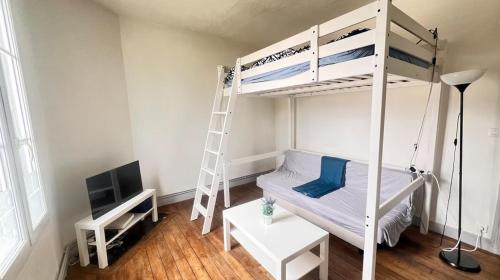 L'oasis de l'Yonne في Migennes: غرفة صغيرة مع سرير بطابقين وتلفزيون