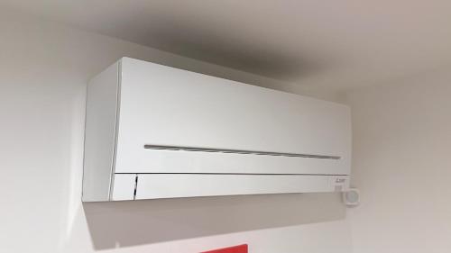 een witte kast aan een witte muur bij Pomodoro House - Luminoso appartamento vicino Linate, Sky, Fabrique, Arena Santa Giulia in Milaan