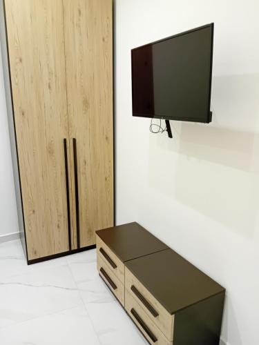 Il Don Giovanni Room في بارليتا: تلفزيون جالس على جدار بجانب دولاب