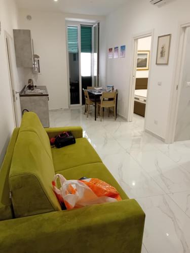 Il Don Giovanni Room في بارليتا: غرفة معيشة مع أريكة خضراء وطاولة