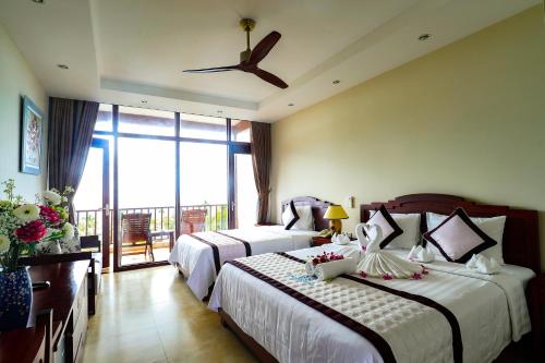 1 dormitorio con 2 camas y ventilador de techo en Tropicana Resort Phu Quoc, en Phu Quoc