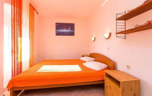 ein kleines Schlafzimmer mit einem orangenen Bett in einem Zimmer in der Unterkunft Apartments Samia in Medulin