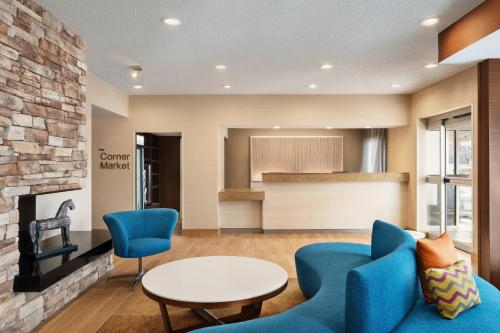a living room with blue chairs and a table at Fairfield Inn by Marriott Deptford in Deptford