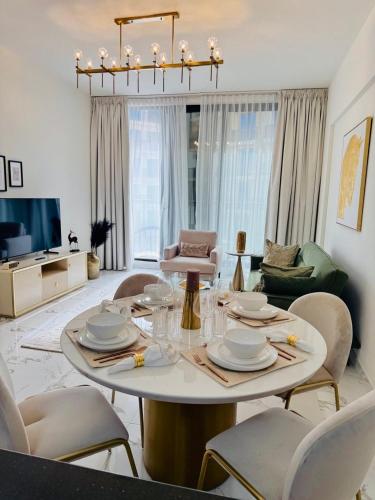 a living room with a table and chairs at Luxurious 1BR Apartment with Private Beach in Ras al Khaimah