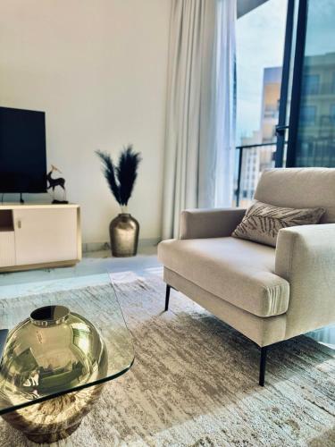 a living room with a couch and a glass table at Luxurious 1BR Apartment with Private Beach in Ras al Khaimah