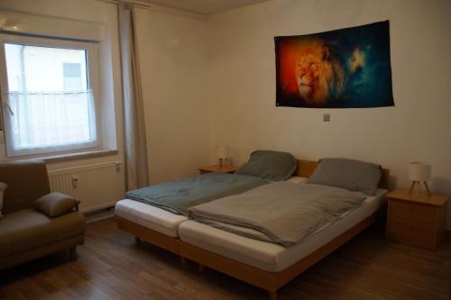 ヘルツォーゲンアウラッハにあるFortl's Apartmentのベッドと壁に絵が飾られた寝室