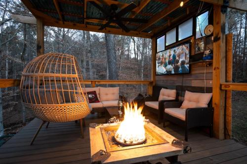 a fire pit on a screened in porch with chairs and a television at Charming Hideaway 1 BR APT 10 min to UGA in Athens