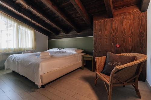 ein Schlafzimmer mit einem Bett, einem Stuhl und einem Fenster in der Unterkunft Casa Laret 6-12 in Laax-Murschetg