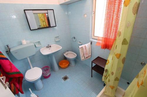 a blue bathroom with a toilet and a sink at House Paulina in Banjole