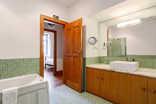 un bagno con vasca, lavandino e specchio di Casa dos Avós a Perre
