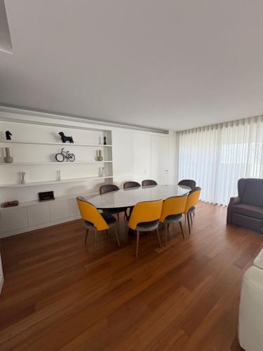a dining room with a table and yellow chairs at Luxury River View 3BR with Pool by Airport in Lisbon