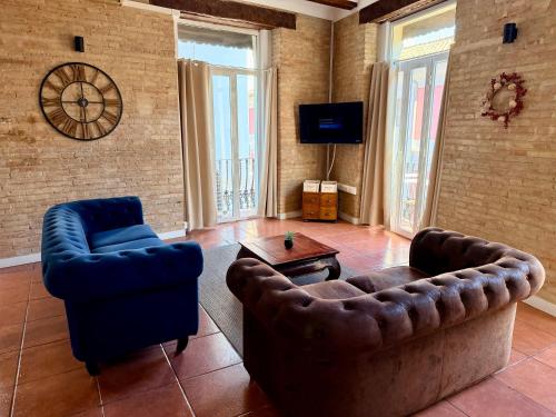 ein Wohnzimmer mit zwei Stühlen und einer Couch und einem Fernseher in der Unterkunft Teixidors de Palomar - PalomarGroup in Valencia