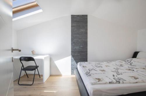 een slaapkamer met een bed en een stoel naast een bureau bij House Bernarda in Medulin