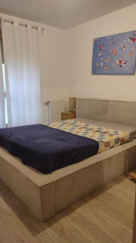 a large bed in a bedroom with a blue comforter at T3 lumineux avec balcon, proche des transports in La Celle-sous-Gouzon