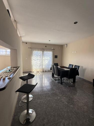 ルハン・デ・クージョにあるLos Álamos - Casa moderna y ampliaのダイニングテーブルと椅子のあるリビングルーム