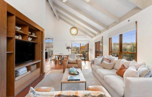 un soggiorno con un divano bianco e una TV di Coastal Timber Escape with Pool a Ocean Grove