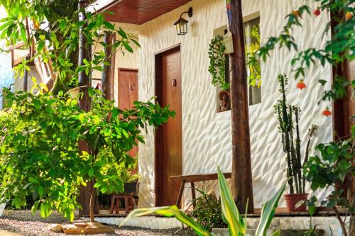 ein Haus mit Bäumen und Pflanzen davor in der Unterkunft Recanto caracol in Alto Paraíso de Goiás