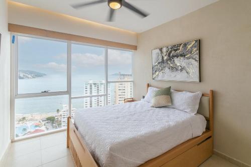 a bedroom with a bed and a large window at Amazing Condo Ocean View By Bamboo Skylife in Acapulco